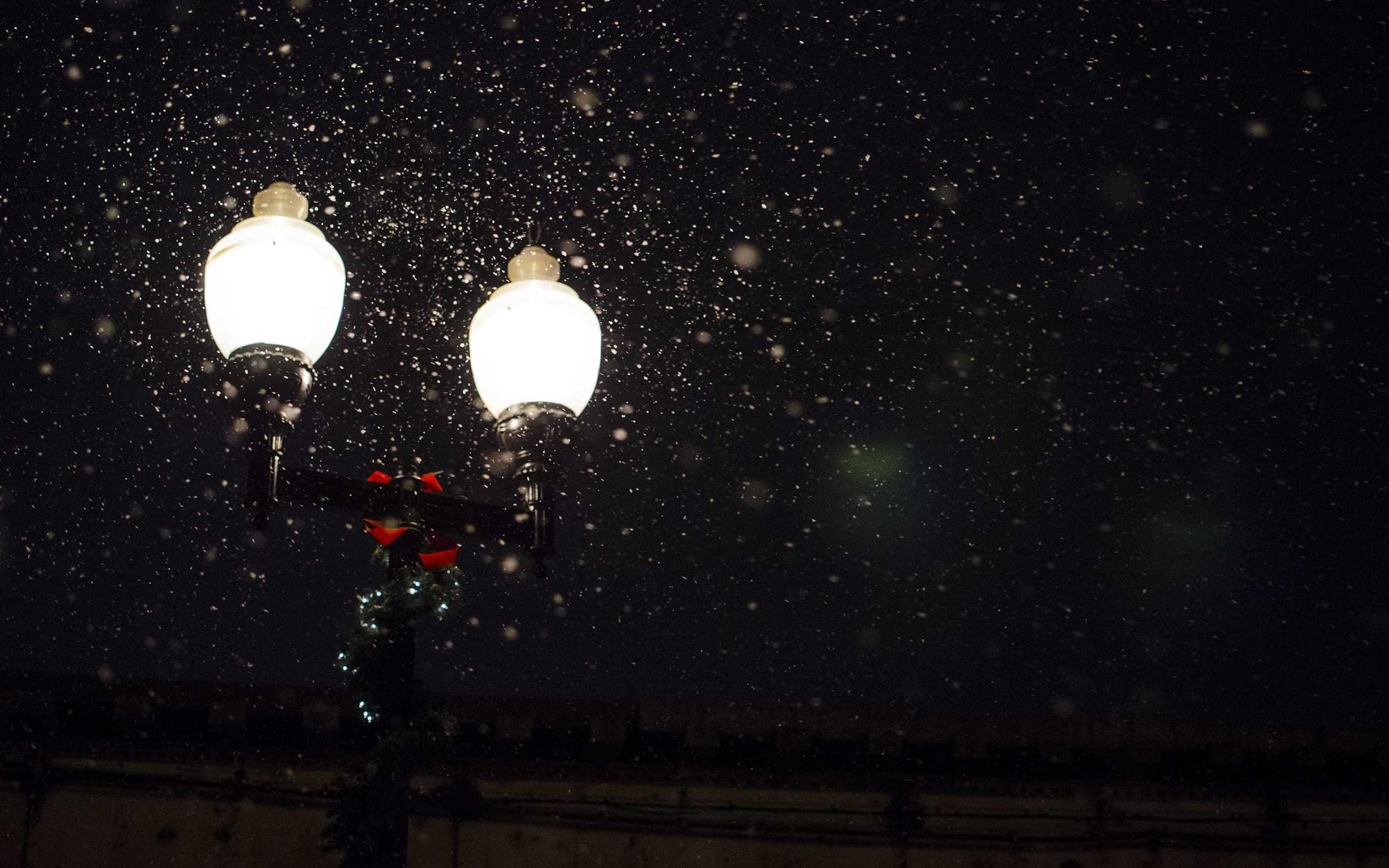 Laterne im Regen vor dunkler Fassade bei Nacht. Foto: Heather Sheppard