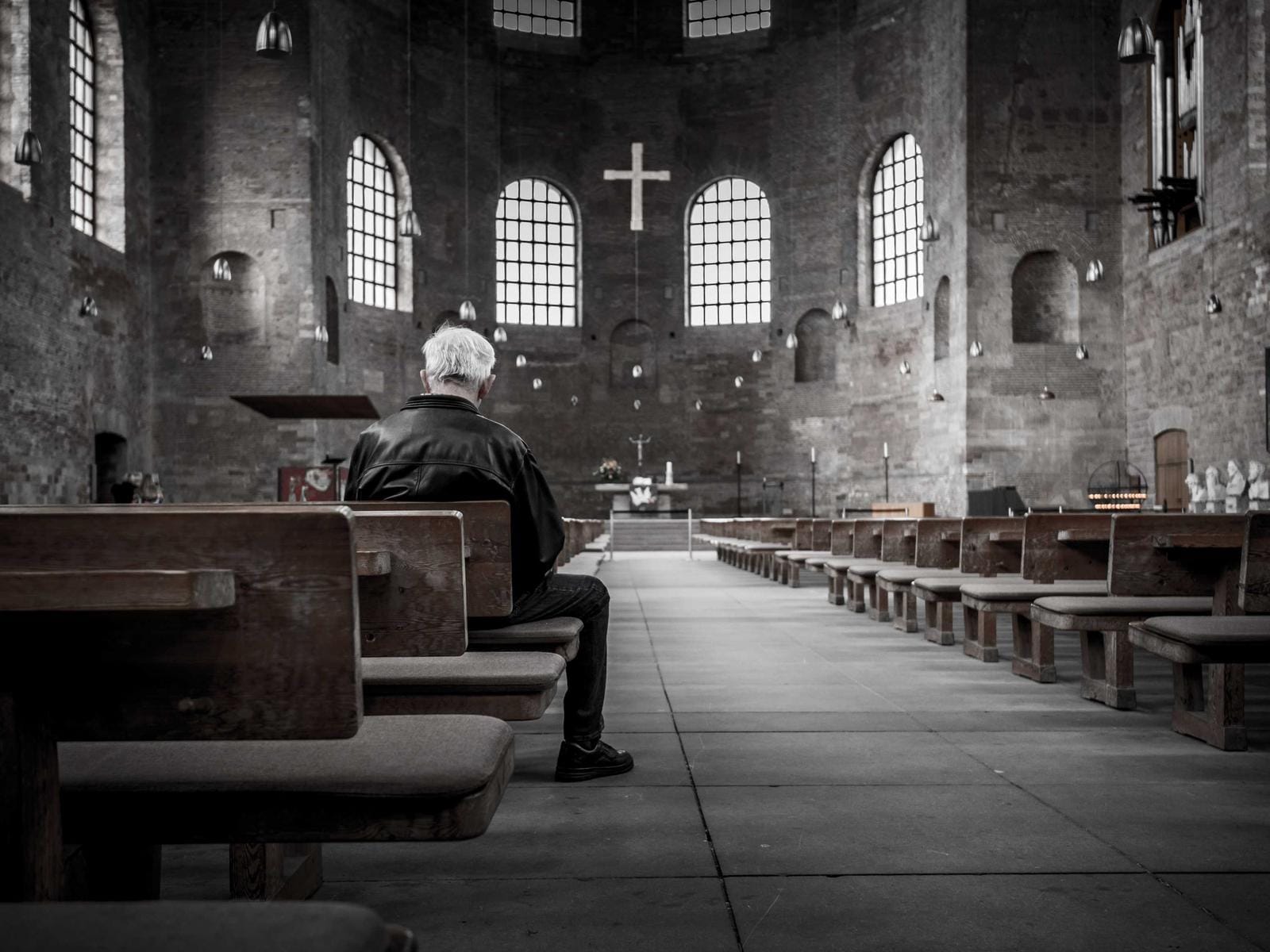 Alter Saal in Grautönen, Reihen von Bänken im Abendlicht. Foto: Pawel Janiak